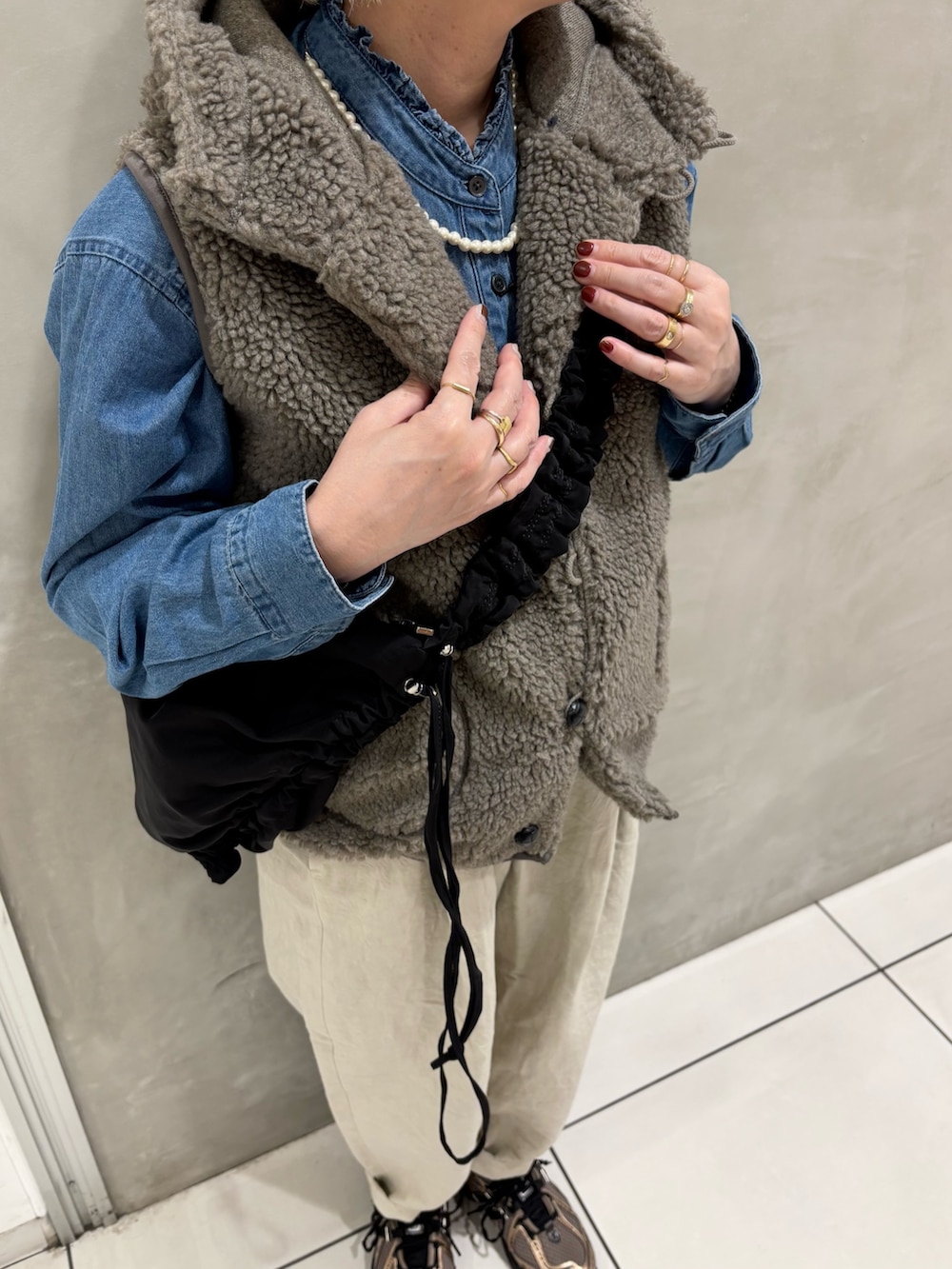 ブルー系のシャツ/ブラウス、ベージュ系のその他アウター、ブラック系のショルダーバッグを着用したレディースの秋コーディネートの5枚目の写真