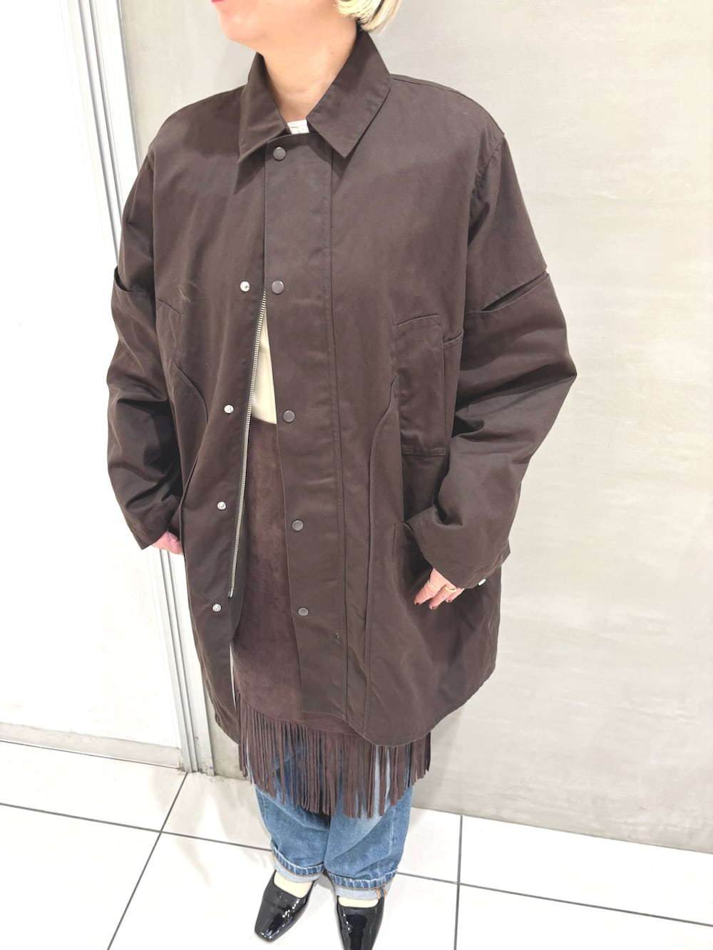 ブラウン系のその他アウター、ホワイト系のTシャツ/カットソー、ブラウン系のスカートを着用したレディースの秋コーディネートの5枚目の写真