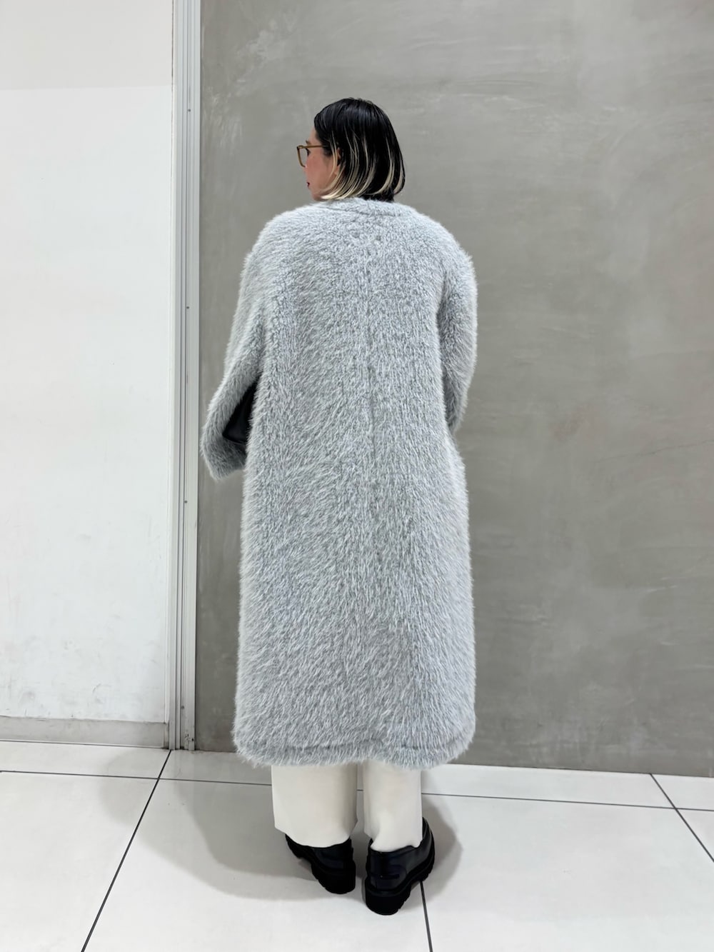 ブルー系のその他アウター、ブルー系のシャツ/ブラウス、ブラウン系のニット/セーターを着用したレディースの冬コーディネートの2枚目の写真