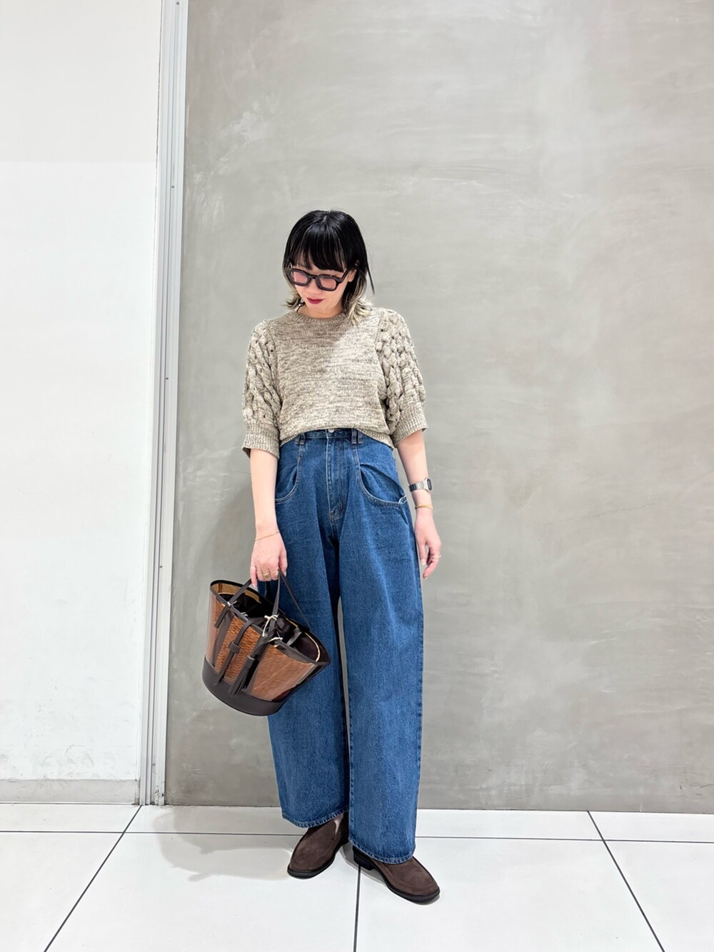 ホワイト系のニット/セーター、ブルー系のデニムパンツ、ブラウン系のローファーを着用したレディースの春コーディネートの4枚目の写真