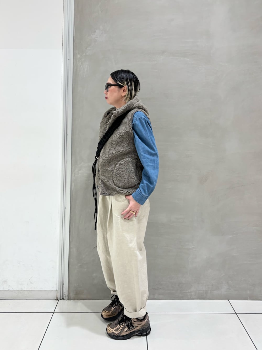 ブルー系のシャツ/ブラウス、ベージュ系のその他アウター、ブラック系のショルダーバッグを着用したレディースの秋コーディネートの3枚目の写真