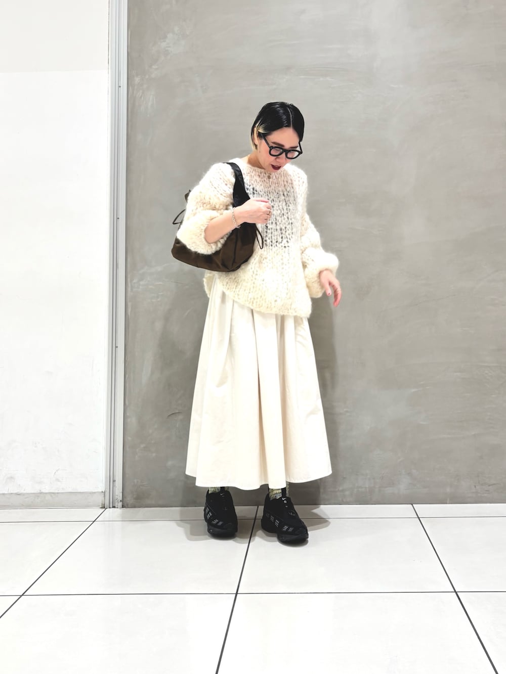 ホワイト系のニット/セーター、ホワイト系のスカート、ブラウン系のショルダーバッグを着用したレディースの秋コーディネートの4枚目の写真