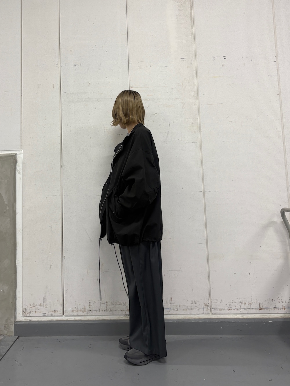 ブラック系のモッズコート、グレー系のカーディガン/ボレロ、グレー系のその他パンツを着用したレディースの冬コーディネートの2枚目の写真