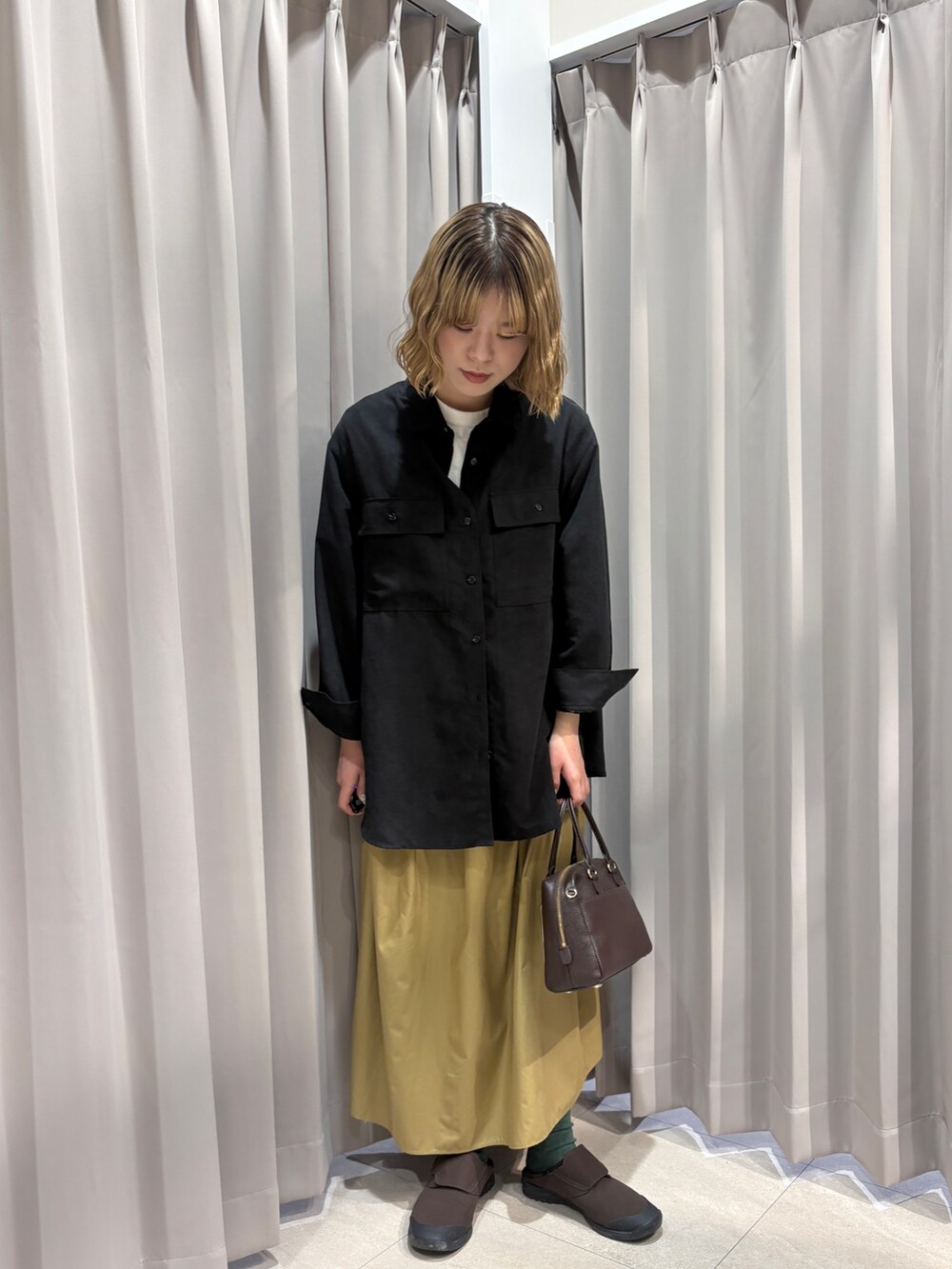 ブラック系のシャツ/ブラウス、イエロー系のスカートを着用したレディースの春コーディネートの4枚目の写真