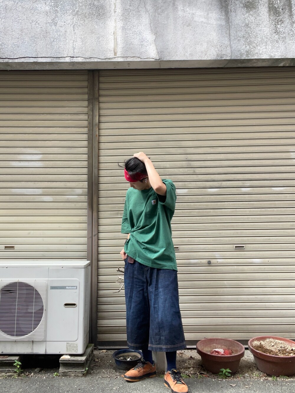 グリーン系のTシャツ/カットソー、ブルー系のデニムパンツ、ブラウン系のスニーカーを着用したメンズの秋コーディネートの2枚目の写真