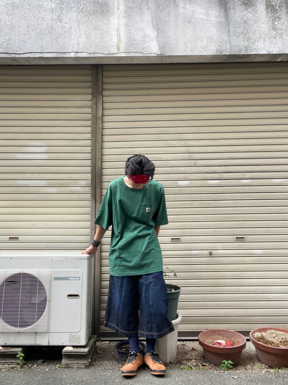 グリーン系のTシャツ/カットソー、ブルー系のデニムパンツ、ブラウン系のスニーカーを着用したメンズの秋コーディネートの3枚目の写真