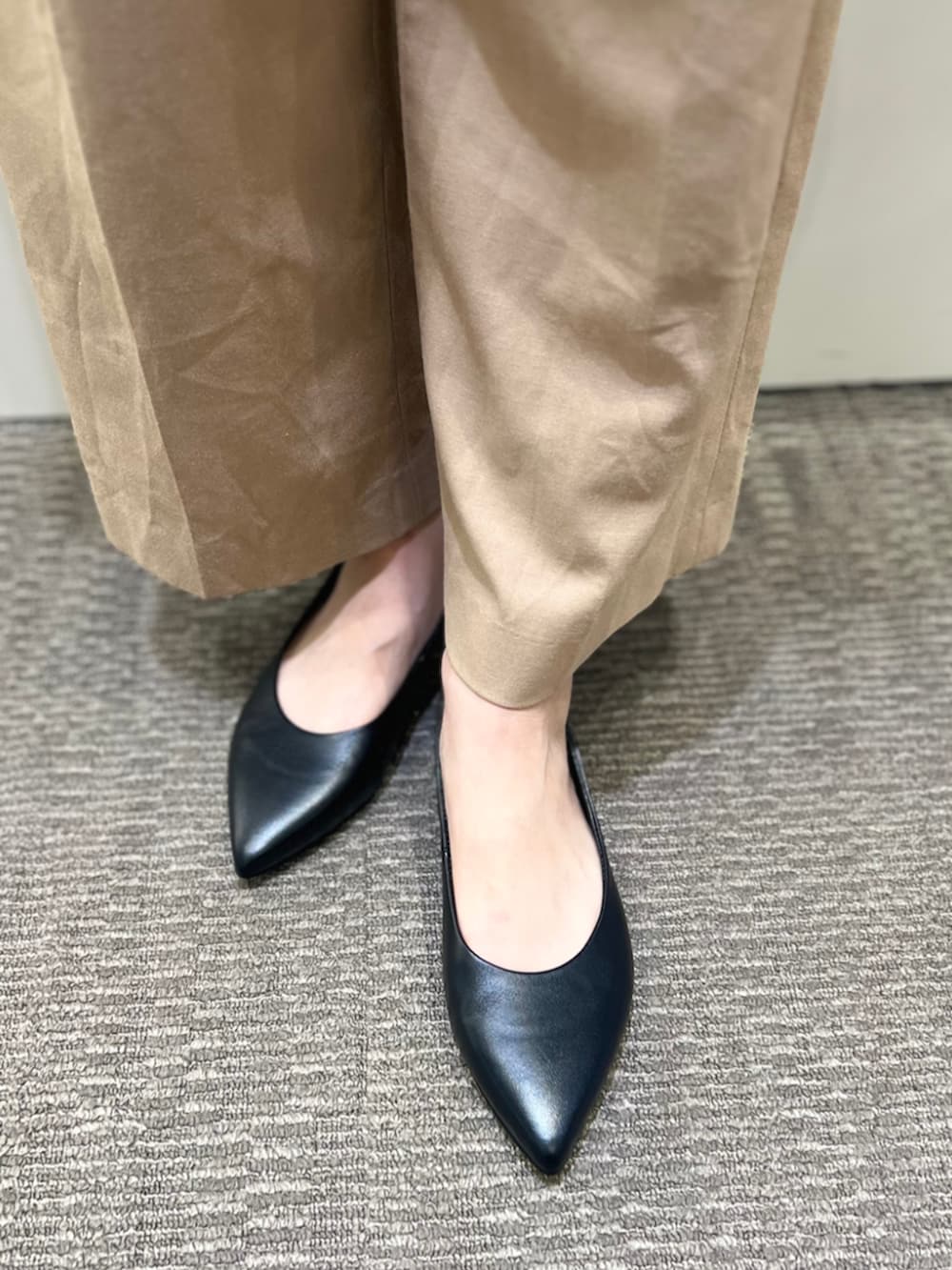 ブラック系のパンプスを着用したレディースの冬コーディネートの2枚目の写真