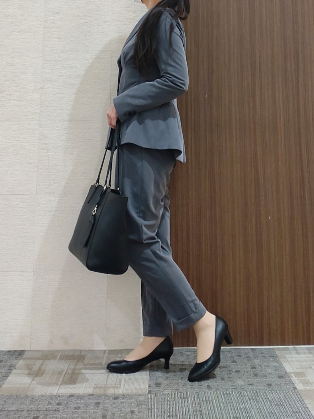 ブラック系のパンプスを着用したレディースの冬コーディネートの2枚目の写真