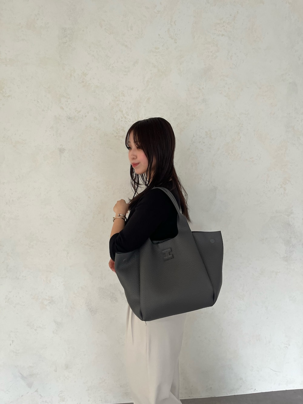 グレー系のトートバッグを着用したレディースの夏コーディネートの3枚目の写真