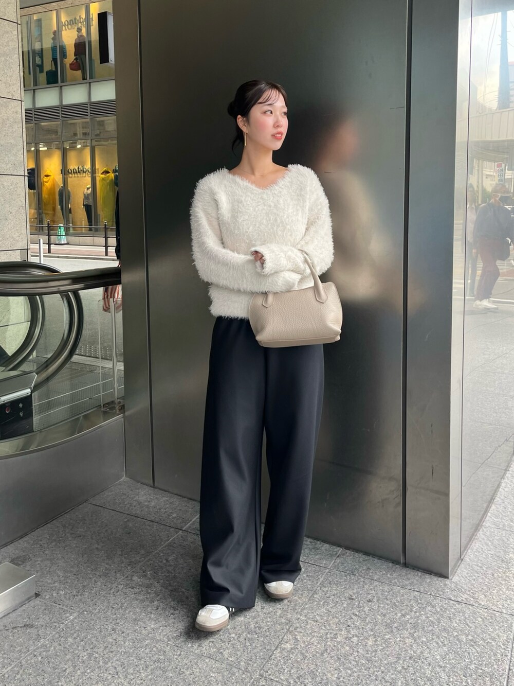 ベージュ系のショルダーバッグを着用したレディースの秋コーディネートの2枚目の写真