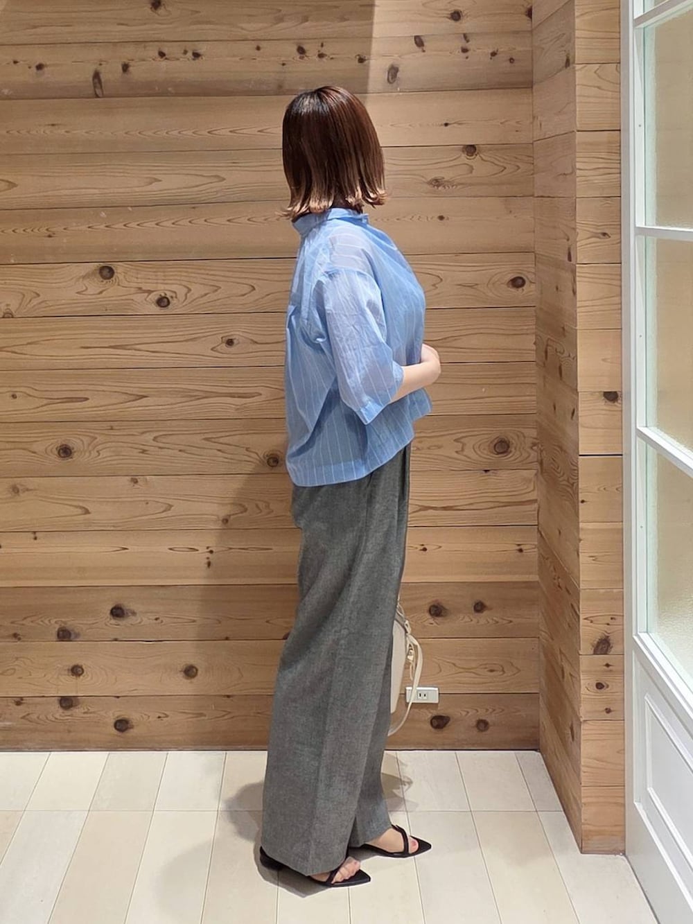 グレー系のその他パンツ、ブルー系のシャツ/ブラウス、ホワイト系のタンクトップを着用したレディースの夏コーディネートの2枚目の写真