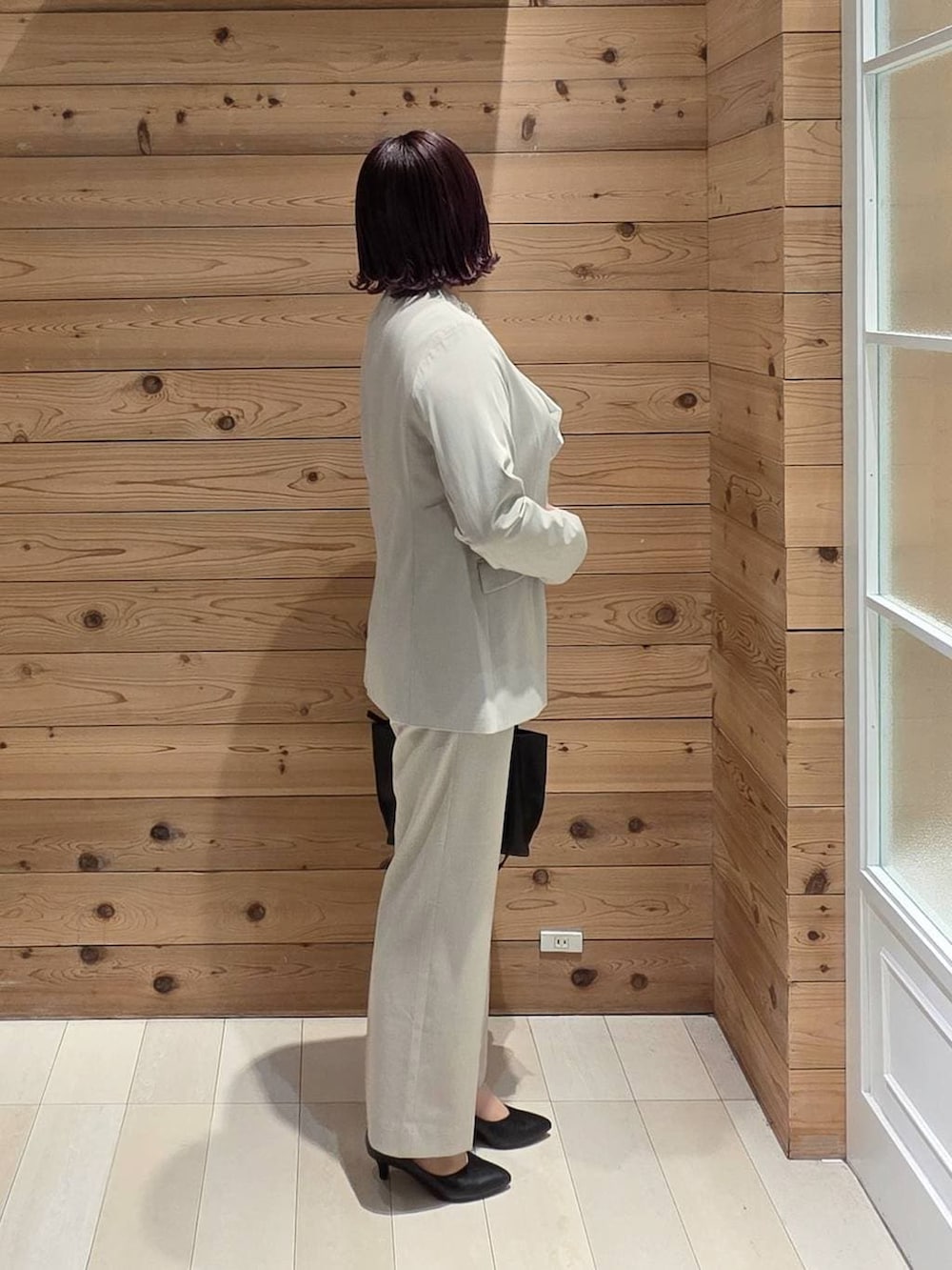 ブラック系のパンプス、ベージュ系のスラックス、ホワイト系のシャツ/ブラウスを着用したレディースの冬コーディネートの2枚目の写真