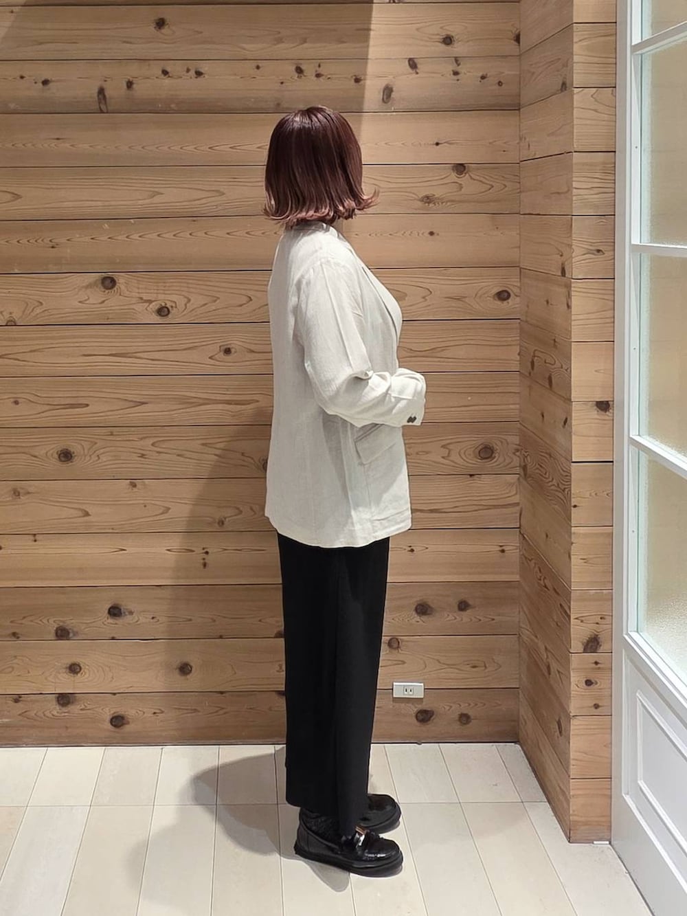 ブラック系のローファー、シルバー系のハンドバッグ、ブラック系のスカートを着用したレディースの春コーディネートの2枚目の写真