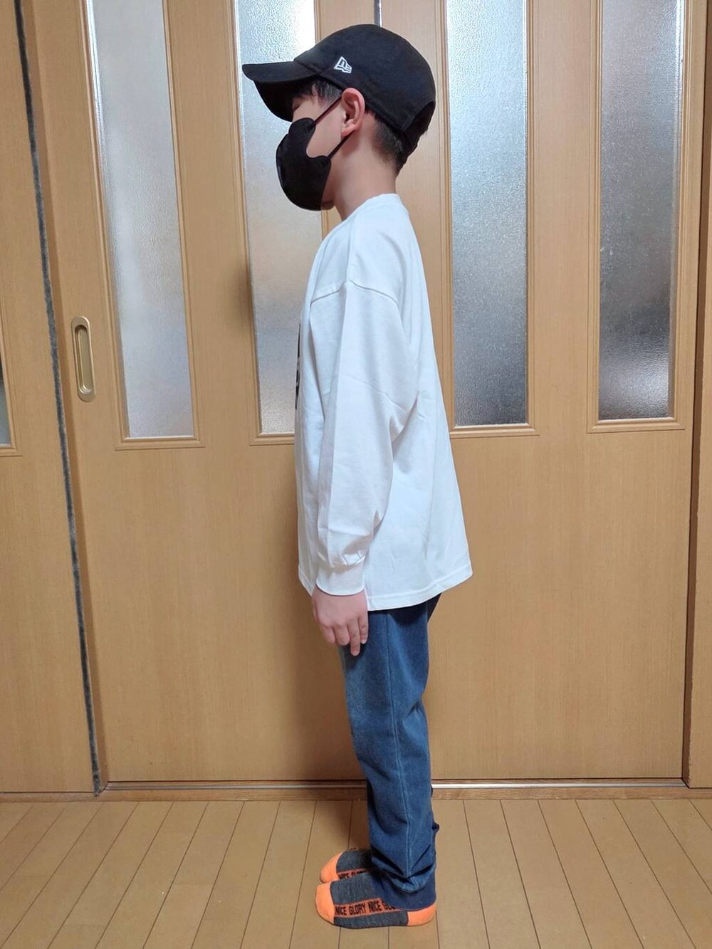 ブルー系のデニムパンツ、ホワイト系のTシャツ/カットソー、ブラック系のキャップを着用したキッズの秋コーディネートの2枚目の写真