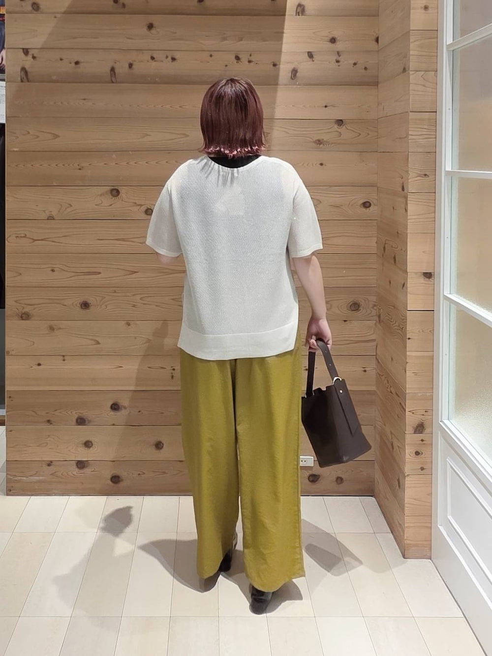 ブラウン系のショルダーバッグ、ブラック系のタンクトップ、ブラック系のパンプスを着用したレディースの夏コーディネートの3枚目の写真