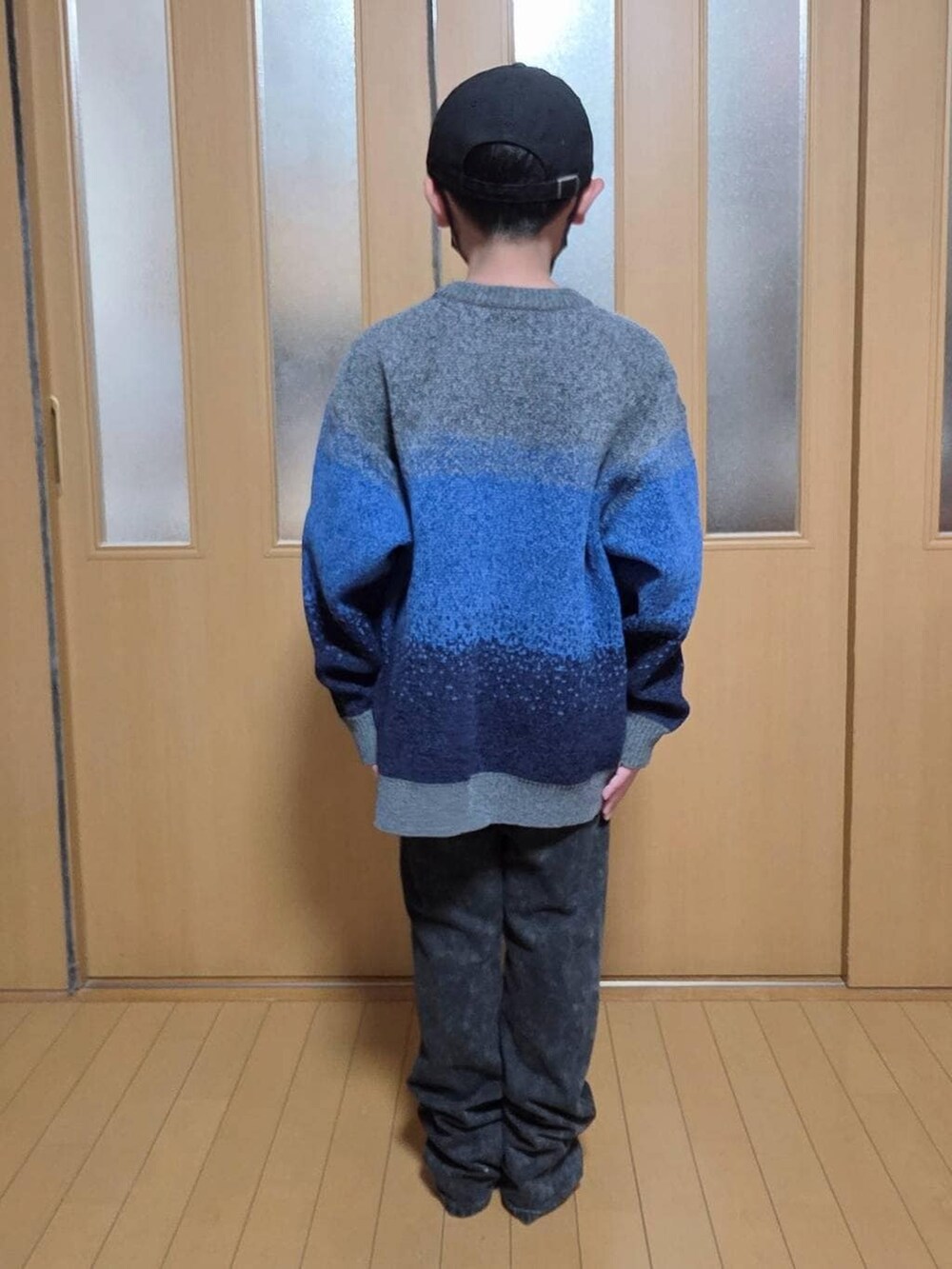 ブラック系のブルゾン、ブラック系のデニムパンツ、グレー系のニット/セーターを着用したキッズの冬コーディネートの3枚目の写真