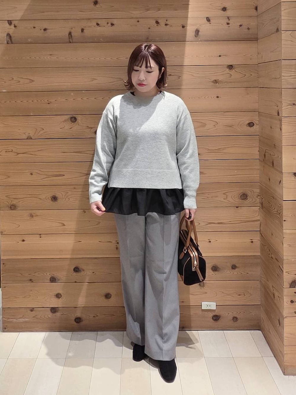 ベージュ系のダウンジャケット/コート、シルバー系のニット/セーター、グレー系のその他パンツを着用したレディースの冬コーディネートの4枚目の写真