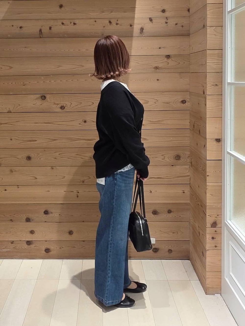 ブラック系のバレエシューズ、ブルー系のデニムパンツ、ブラック系のカーディガン/ボレロを着用したレディースの春コーディネートの2枚目の写真