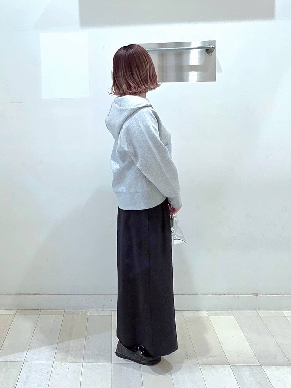 シルバー系のショルダーバッグ、ブラック系のローファー、ホワイト系のTシャツ/カットソーを着用したレディースの春コーディネートの2枚目の写真