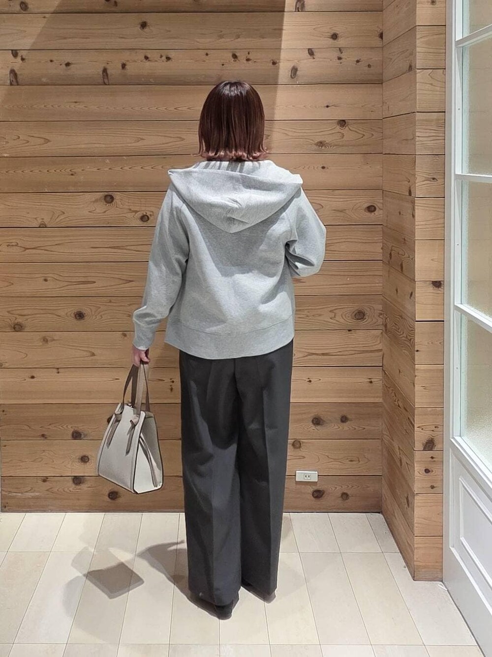 ブラック系のローファー、ホワイト系のショルダーバッグ、グレー系のパーカーを着用したレディースの冬コーディネートの3枚目の写真