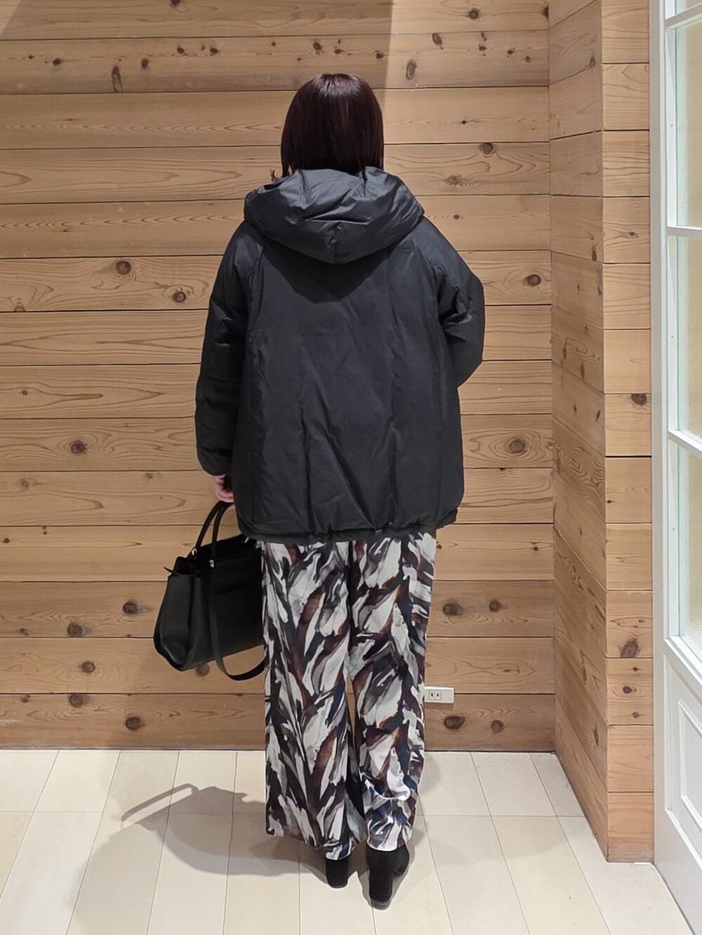 ブラック系のダウンジャケット/コート、ブルー系のニット/セーター、その他のブーツを着用したレディースの冬コーディネートの3枚目の写真