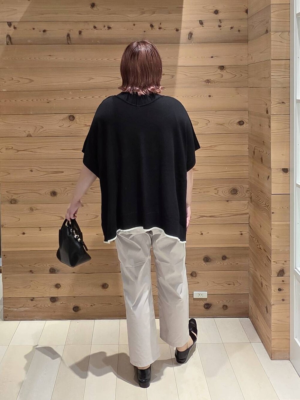 ブラック系のショルダーバッグ、ホワイト系のその他パンツ、ブラック系のニット/セーターを着用したレディースの夏コーディネートの3枚目の写真