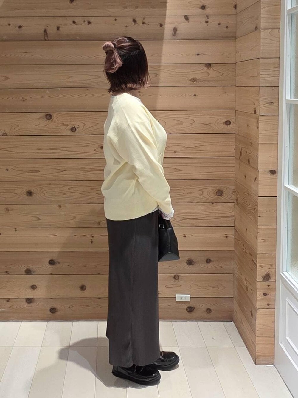 ブラック系のローファー、ブラック系のショルダーバッグ、ホワイト系のTシャツ/カットソーを着用したレディースの冬コーディネートの2枚目の写真