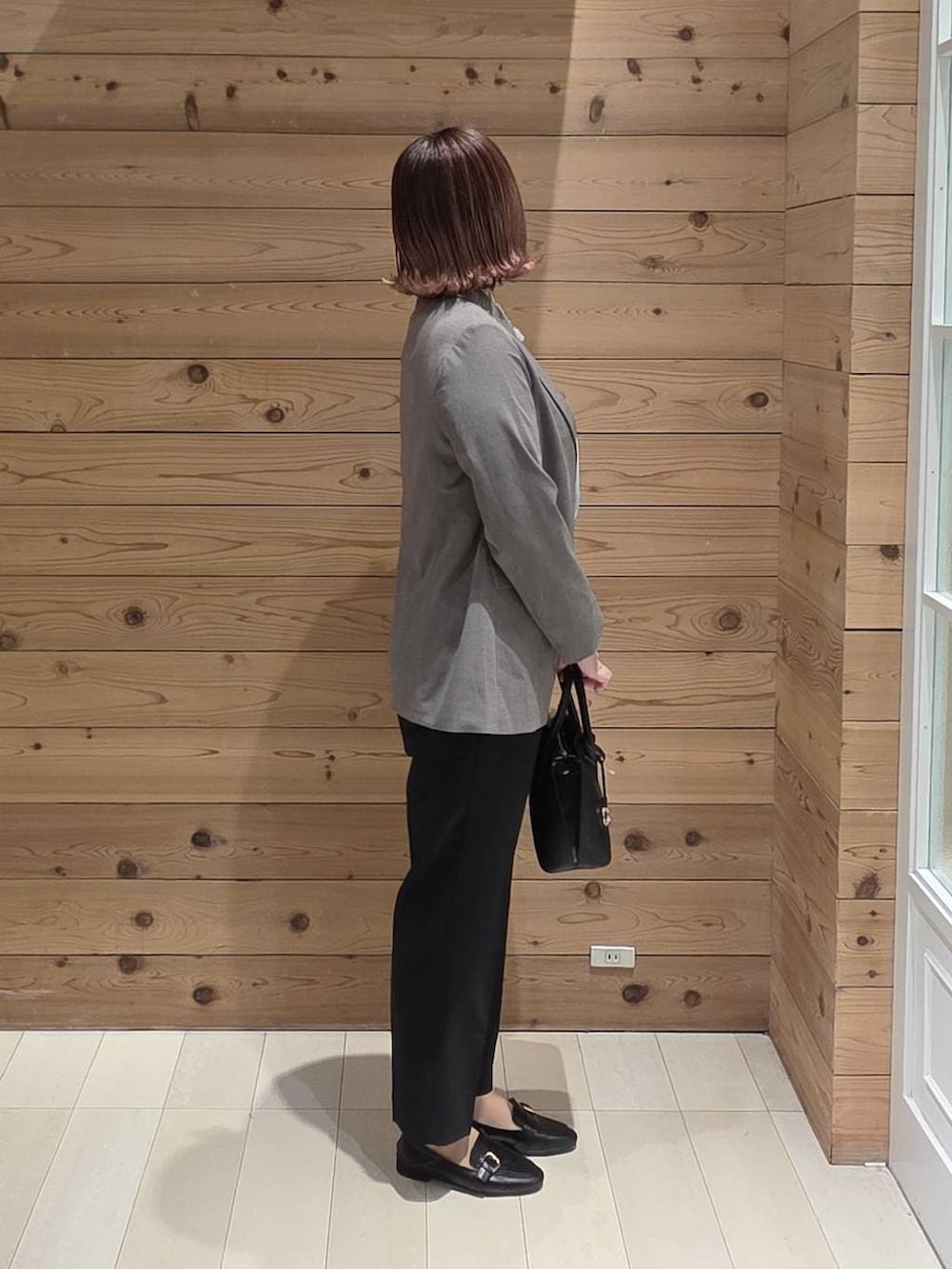 ブラック系のローファー、ブラック系のショルダーバッグ、ブルー系のシャツ/ブラウスを着用したレディースの春コーディネートの2枚目の写真