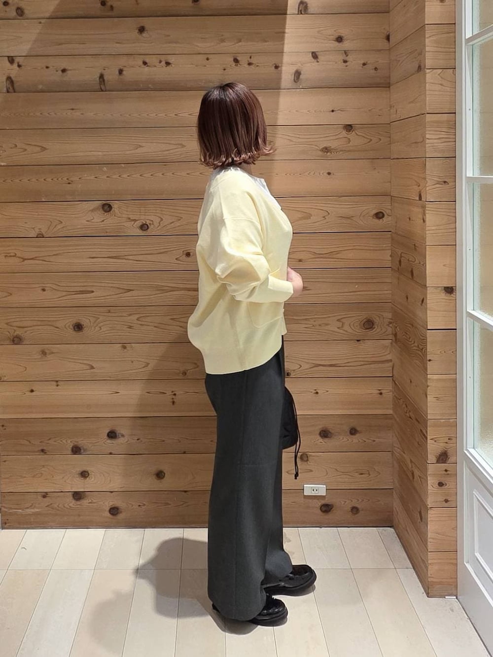 ブラック系のローファー、ブラック系のハンドバッグ、グレー系のその他パンツを着用したレディースの春コーディネートの2枚目の写真