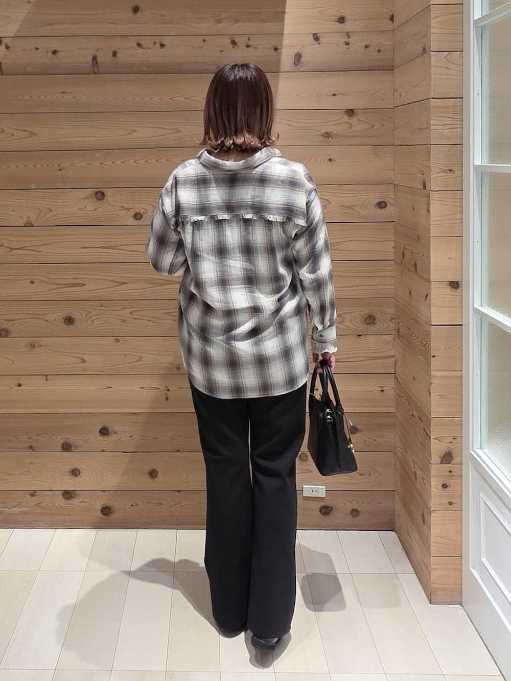 ブラック系のローファー、ブラック系のショルダーバッグ、ホワイト系のTシャツ/カットソーを着用したレディースの春コーディネートの3枚目の写真