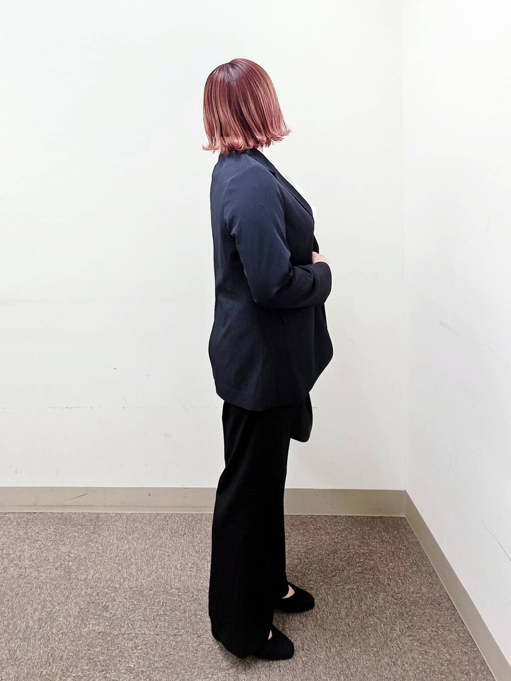 ブラック系のショルダーバッグ、ブラック系のパンプス、ブラック系のスラックスを着用したレディースの冬コーディネートの2枚目の写真