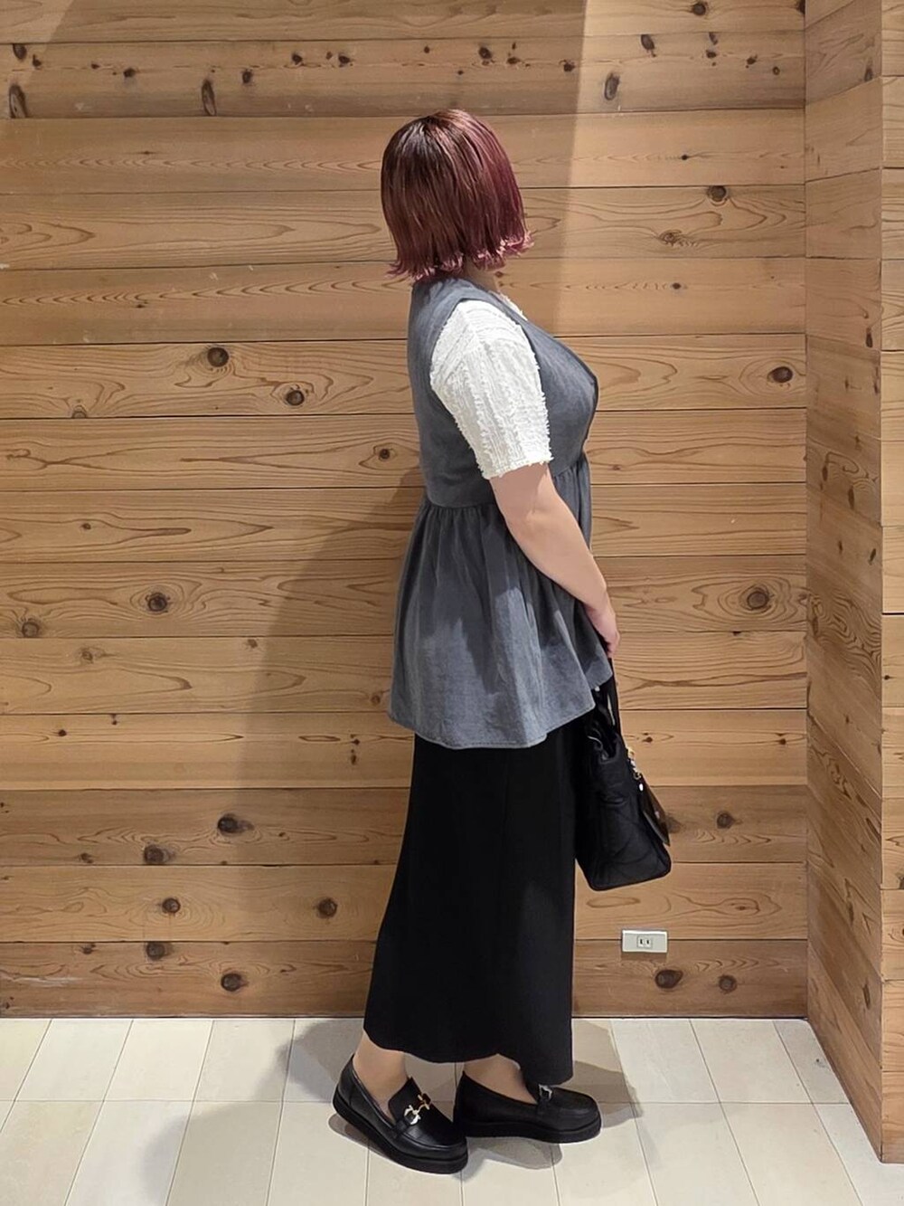 ブラック系のローファー、ブラック系のトートバッグ、ベージュ系のTシャツ/カットソーを着用したレディースの夏コーディネートの2枚目の写真