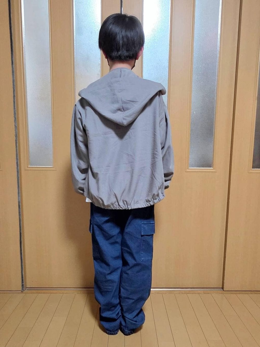 ベージュ系のマウンテンパーカー、ブルー系のカーゴパンツ、ホワイト系のTシャツ/カットソーを着用したキッズの春コーディネートの3枚目の写真