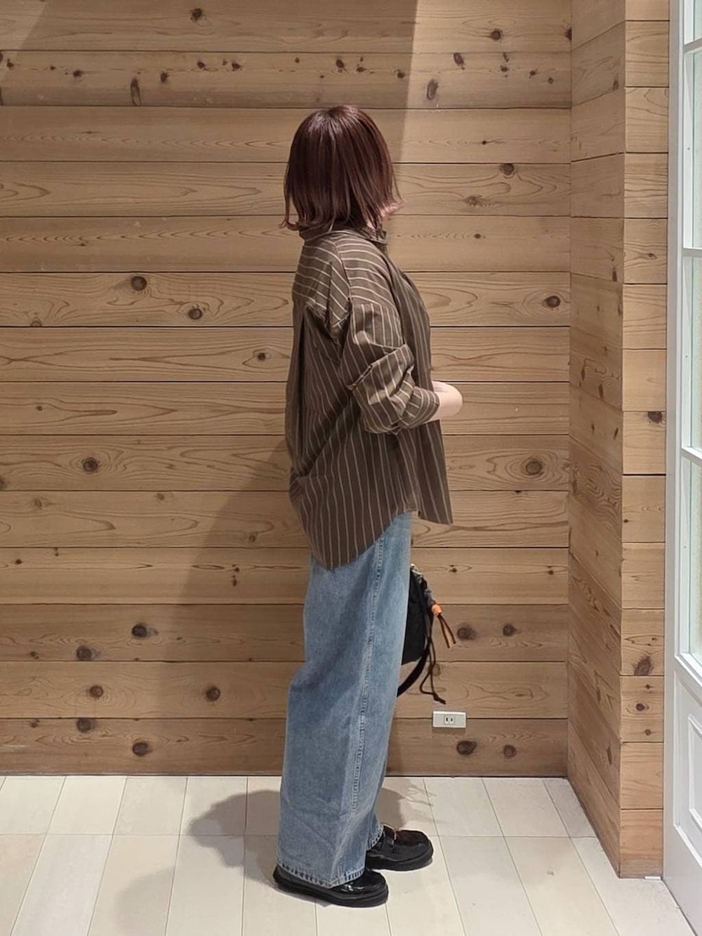 ブラック系のローファー、ブラック系のハンドバッグ、ブラウン系のシャツ/ブラウスを着用したレディースの春コーディネートの2枚目の写真