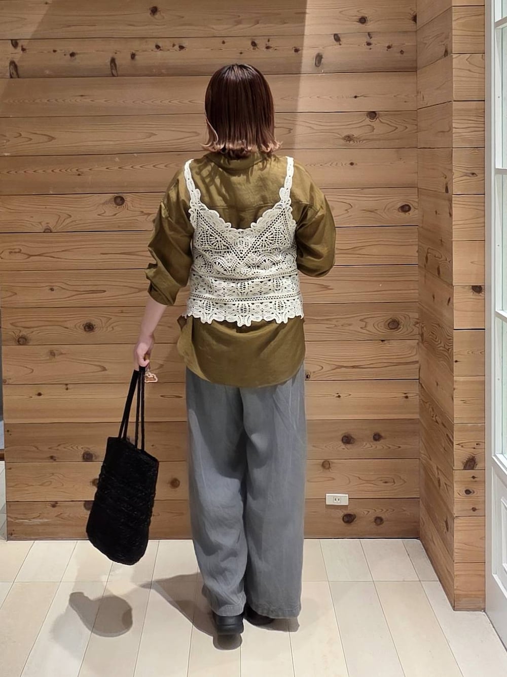 ブラック系のデニムパンツ、ブラック系のクラッチバッグ、ホワイト系のサンダルを着用したレディースの夏コーディネートの3枚目の写真