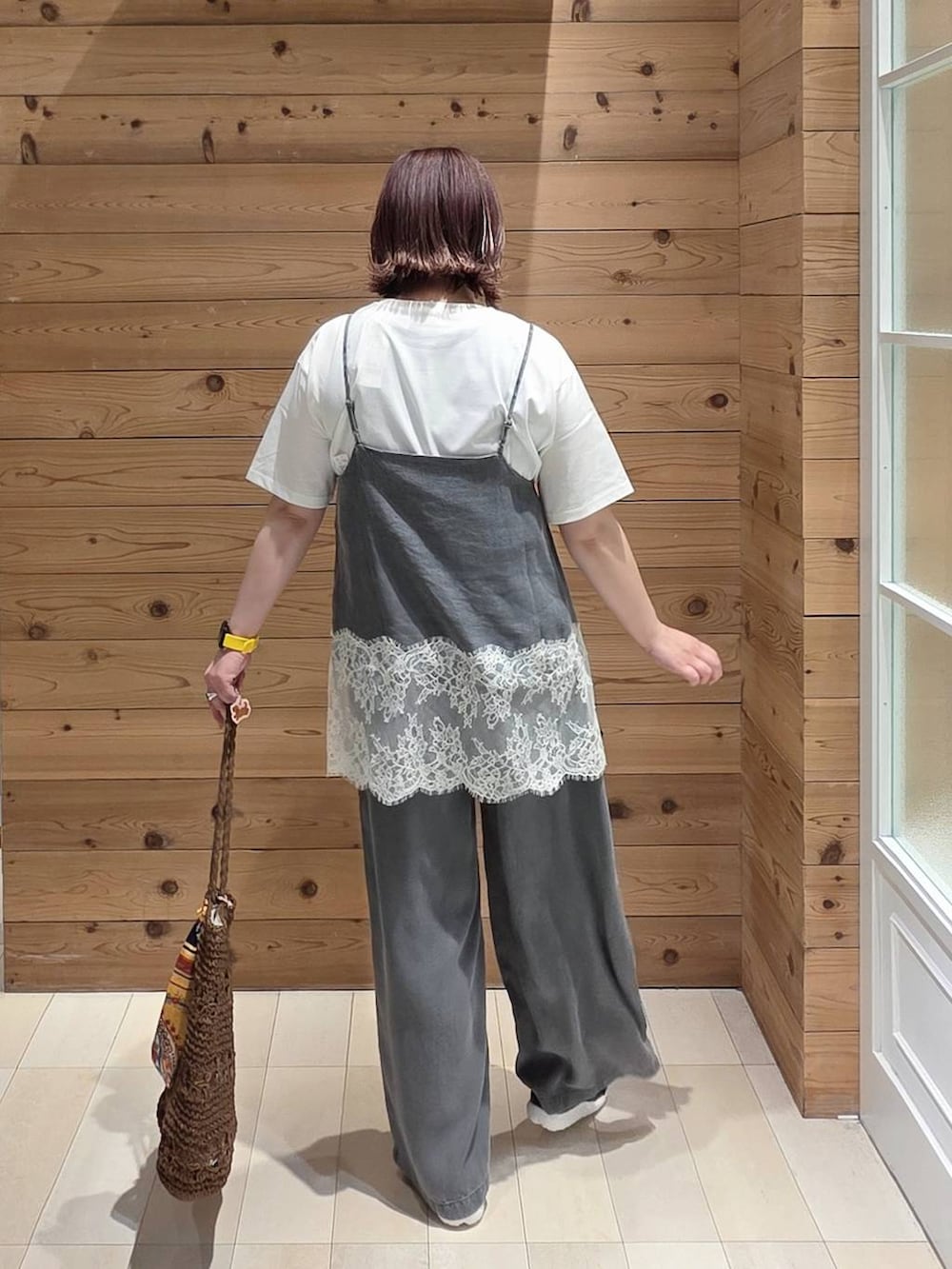 ホワイト系のTシャツ/カットソー、ブラック系のデニムパンツ、ブラウン系のトートバッグを着用したレディースの春コーディネートの3枚目の写真