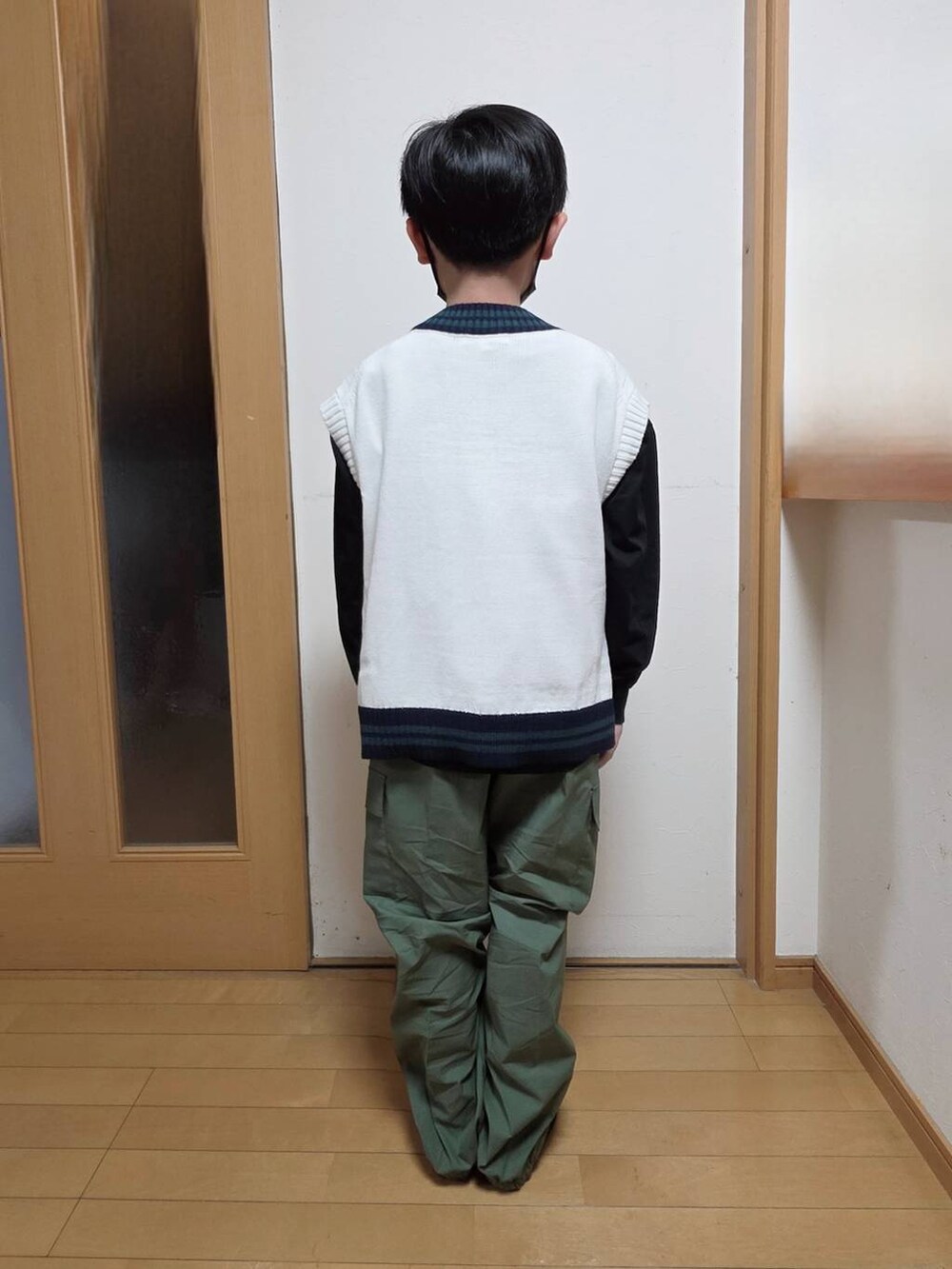 ブラック系のTシャツ/カットソー、グリーン系のカーゴパンツ、ベージュ系のベストを着用したキッズの冬コーディネートの3枚目の写真