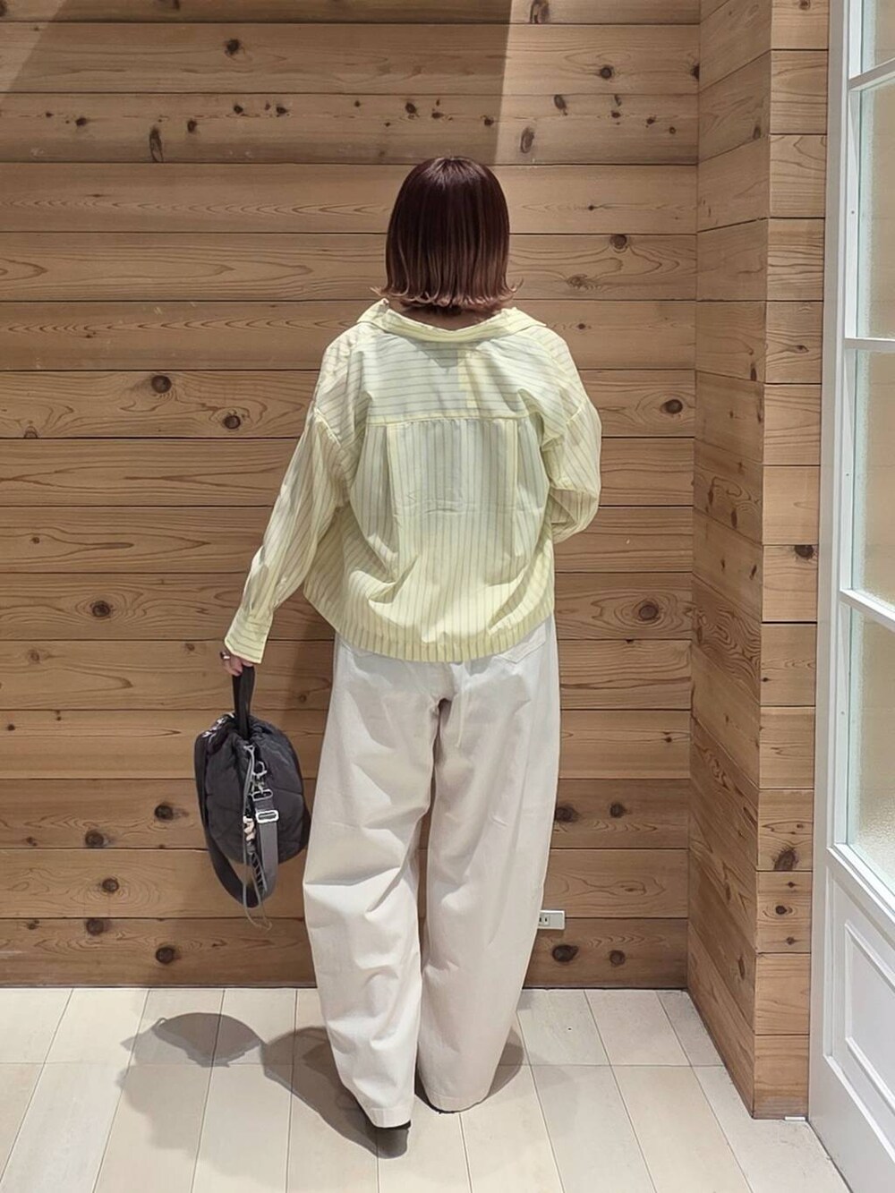 ブラック系のローファー、グレー系のハンドバッグ、ベージュ系のその他パンツを着用したレディースの春コーディネートの3枚目の写真