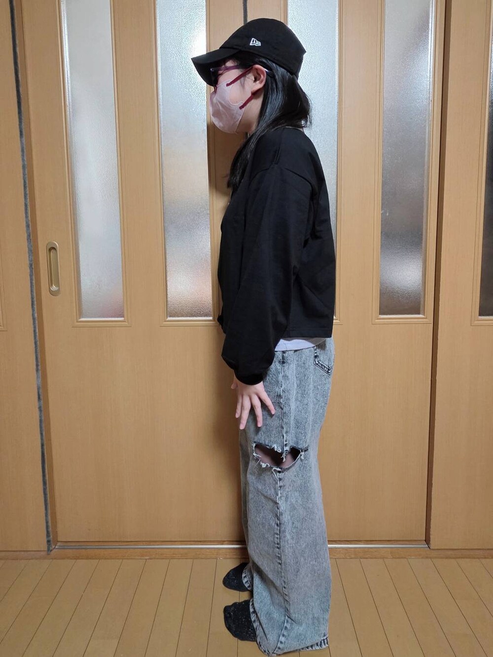 ブラック系のデニムパンツ、ホワイト系のマウンテンパーカー、ブラック系のTシャツ/カットソーを着用したキッズの秋コーディネートの2枚目の写真