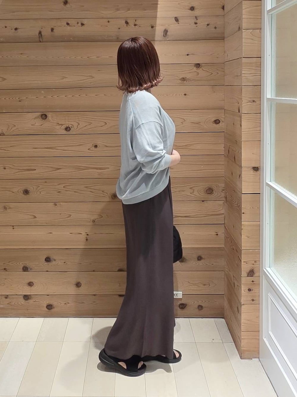 ブラック系のハンドバッグ、ブラウン系のその他パンツ、ホワイト系のTシャツ/カットソーを着用したレディースの春コーディネートの2枚目の写真