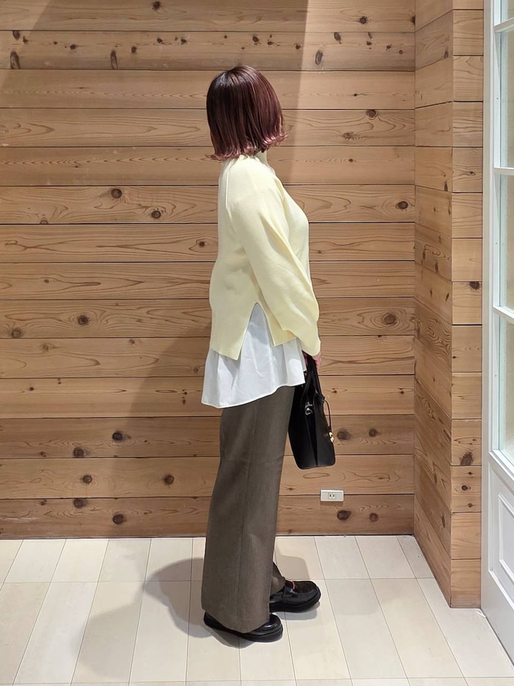 ブラック系のローファー、ブラック系のショルダーバッグ、ホワイト系のTシャツ/カットソーを着用したレディースの冬コーディネートの2枚目の写真