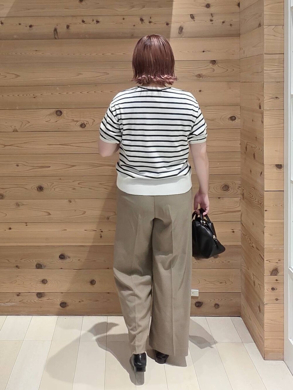 ブラック系のショルダーバッグ、ホワイト系のTシャツ/カットソー、ベージュ系のその他パンツを着用したレディースの夏コーディネートの3枚目の写真