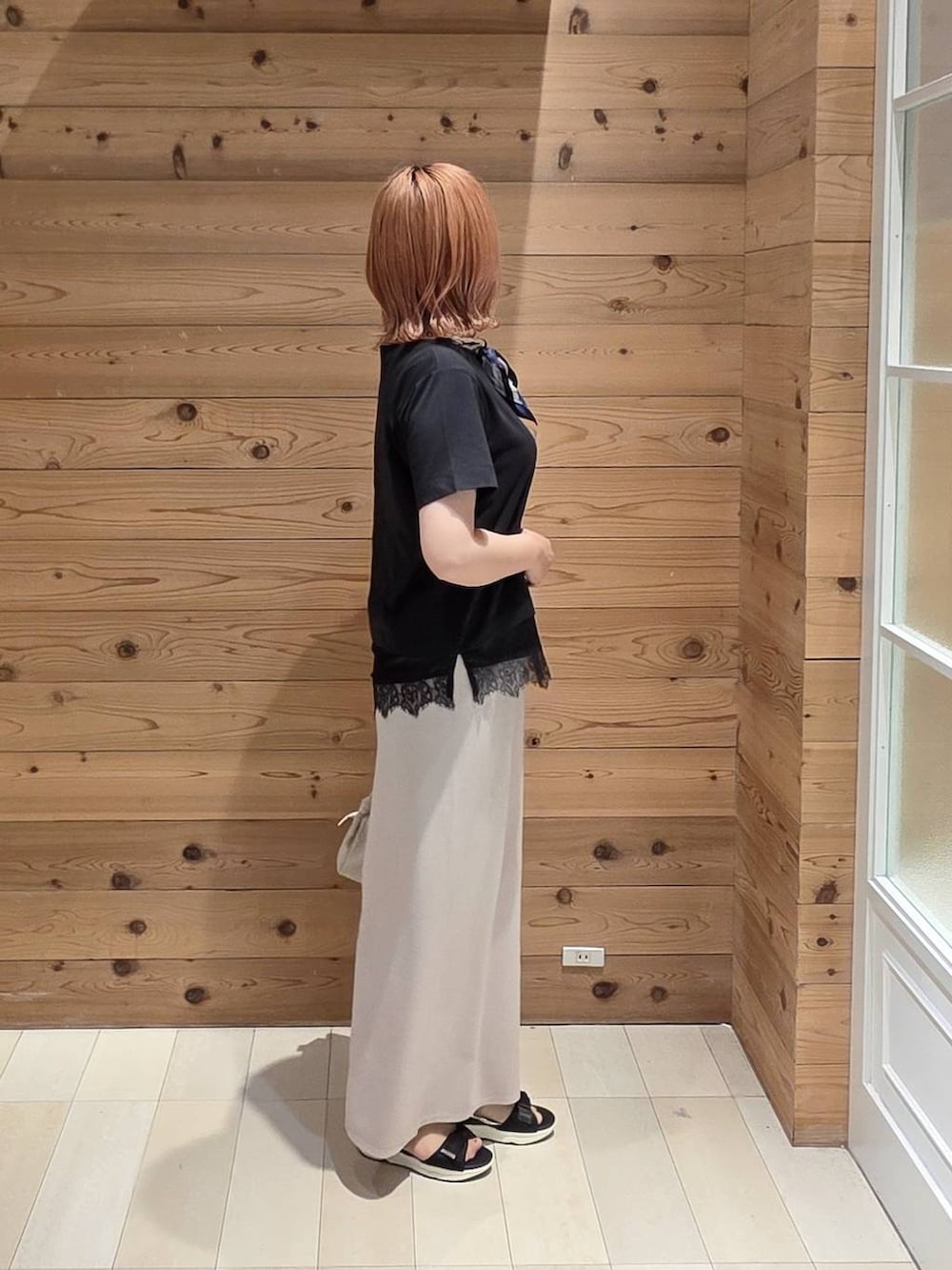 ホワイト系のスカート、ベージュ系のショルダーバッグ、ブラック系のサンダルを着用したレディースの夏コーディネートの2枚目の写真