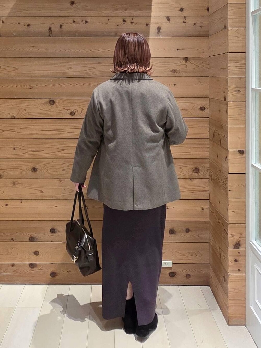 ブラウン系のボストンバッグ、グレー系のワンピース、ホワイト系のTシャツ/カットソーを着用したレディースの冬コーディネートの3枚目の写真