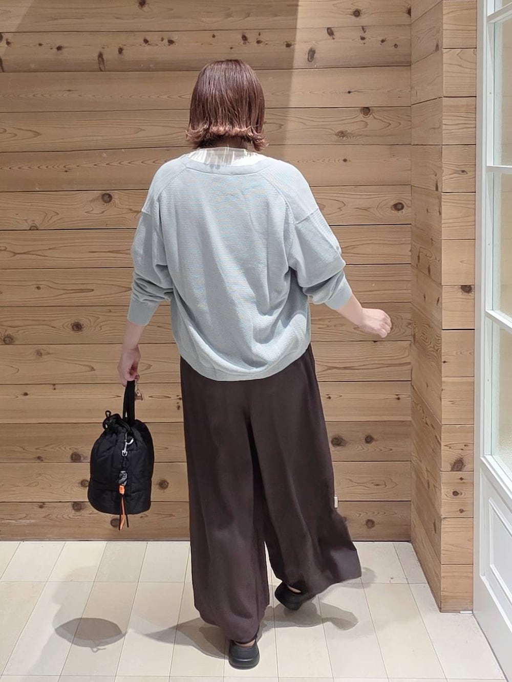 ブラック系のハンドバッグ、ブラウン系のその他パンツ、ホワイト系のTシャツ/カットソーを着用したレディースの春コーディネートの3枚目の写真