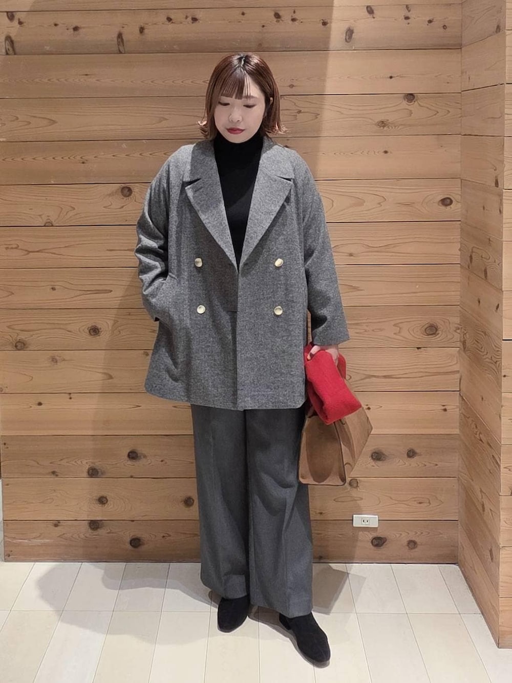 グレー系のチェスターコート、グレー系のその他パンツ、ベージュ系のショルダーバッグを着用したレディースの冬コーディネートの4枚目の写真