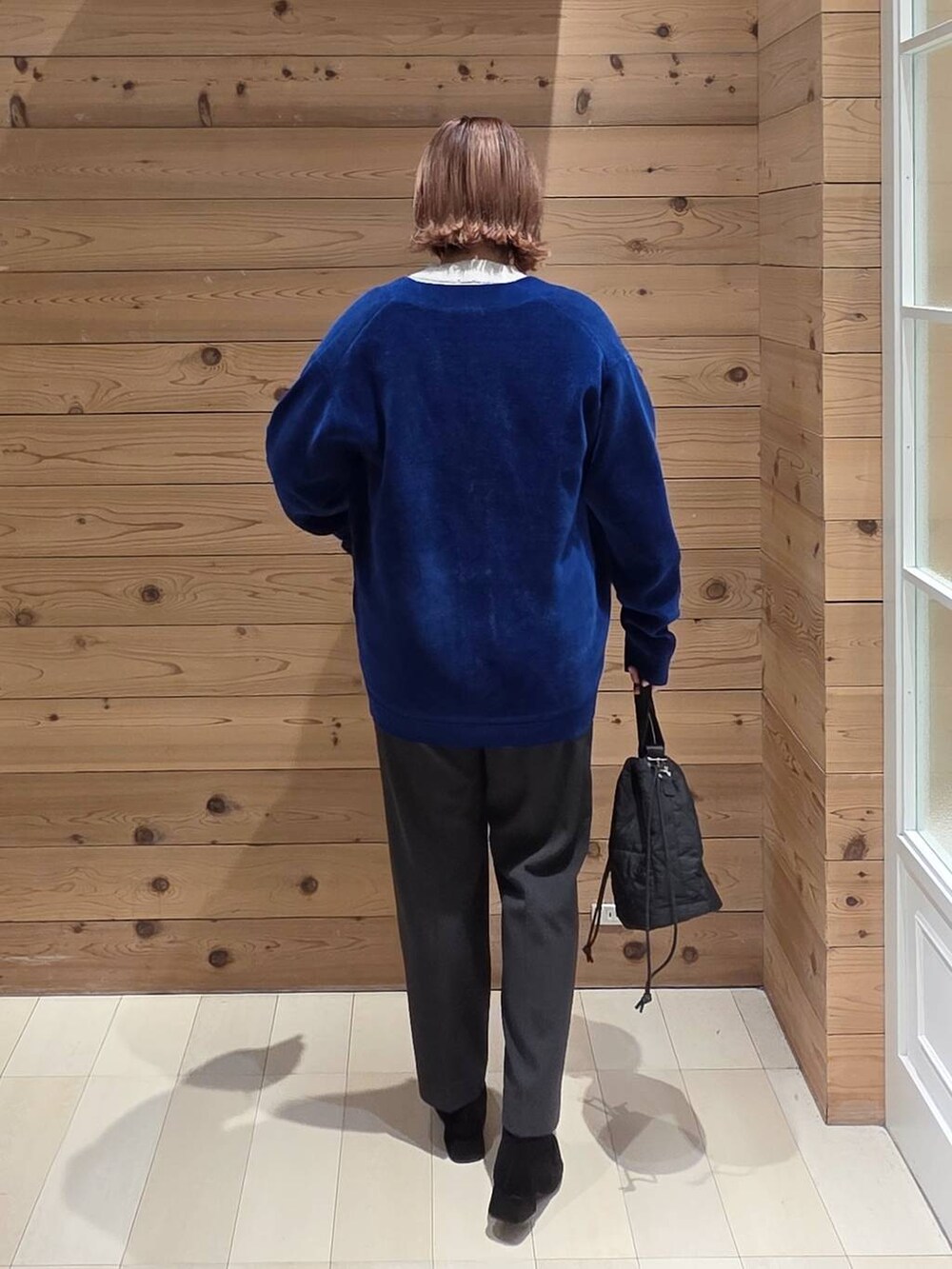 ブラウン系のチェスターコート、グレー系のニット/セーター、グレー系のその他パンツを着用したレディースの秋コーディネートの3枚目の写真
