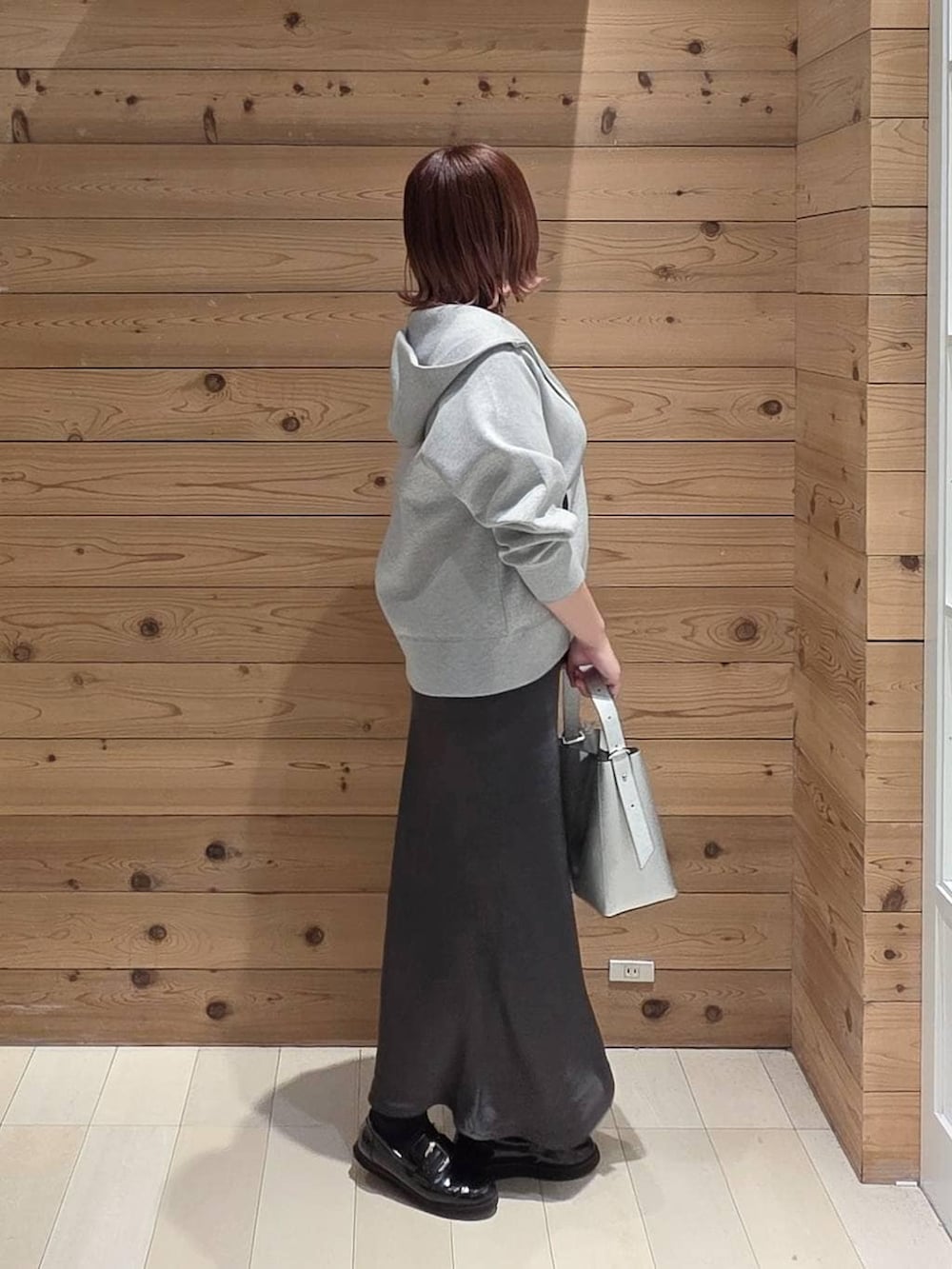 ブラック系のローファー、シルバー系のショルダーバッグ、グレー系のパーカーを着用したレディースの春コーディネートの2枚目の写真