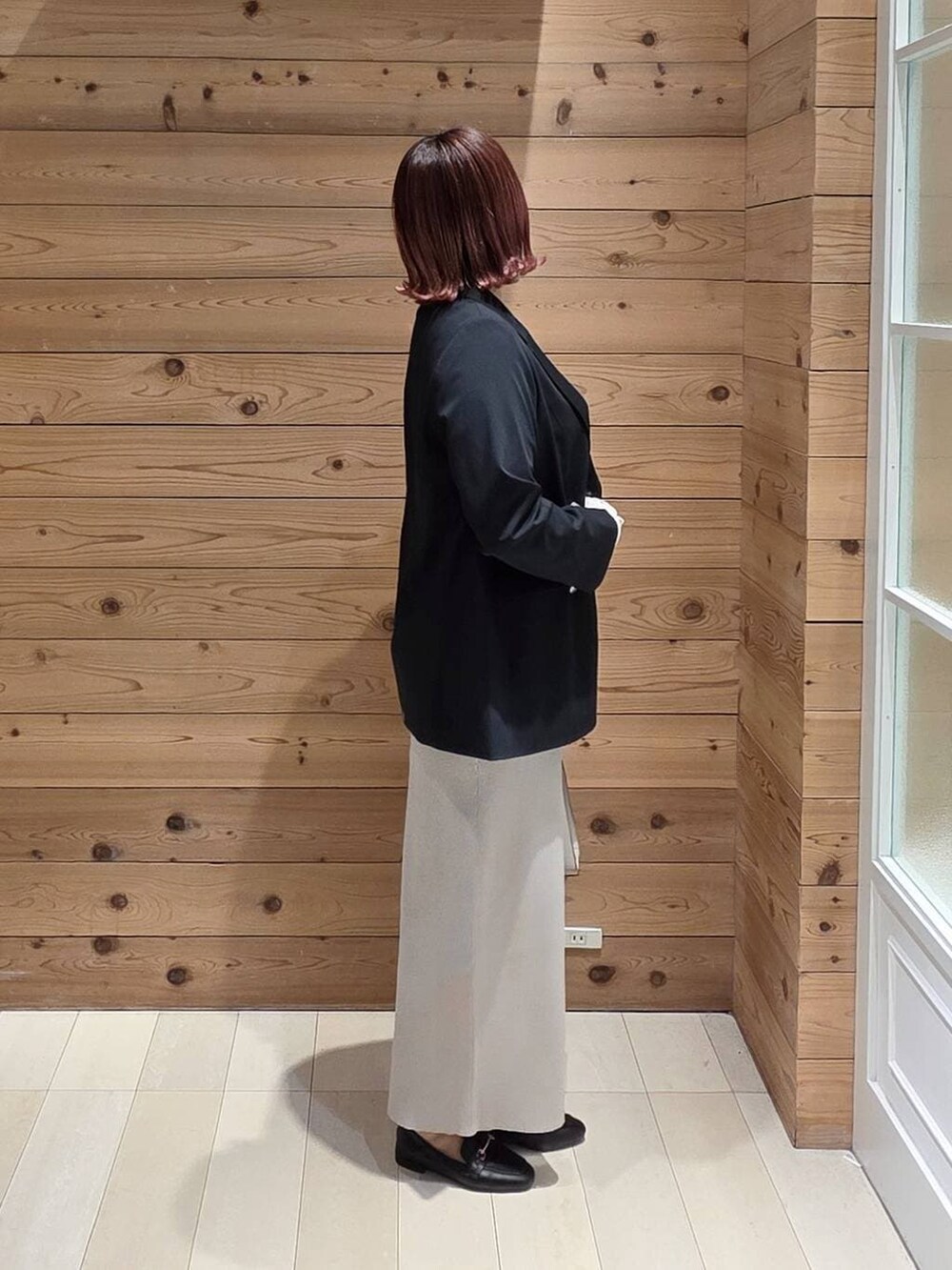 ブラック系のローファー、ホワイト系のショルダーバッグ、ホワイト系のTシャツ/カットソーを着用したレディースの冬コーディネートの2枚目の写真