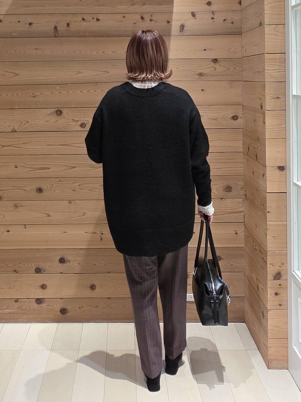 ブラック系のボストンバッグ、ブラック系のダウンジャケット/コート、ブラウン系のその他パンツを着用したレディースの冬コーディネートの3枚目の写真